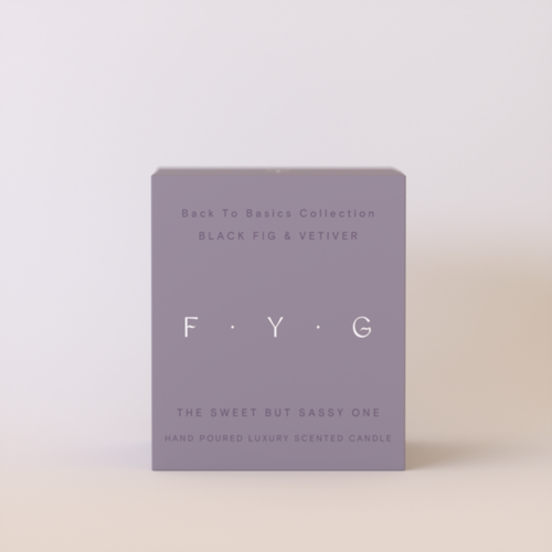 A minimalist rectangular candle box in a muted lavender-gray color, standing upright against a clean, light beige background. The box features the brand name 'F.