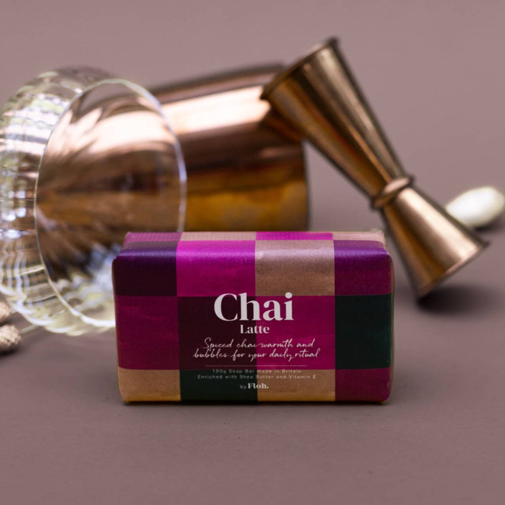 Box of 'Chai Latte' with cocktail shaker and glass on a dark surface