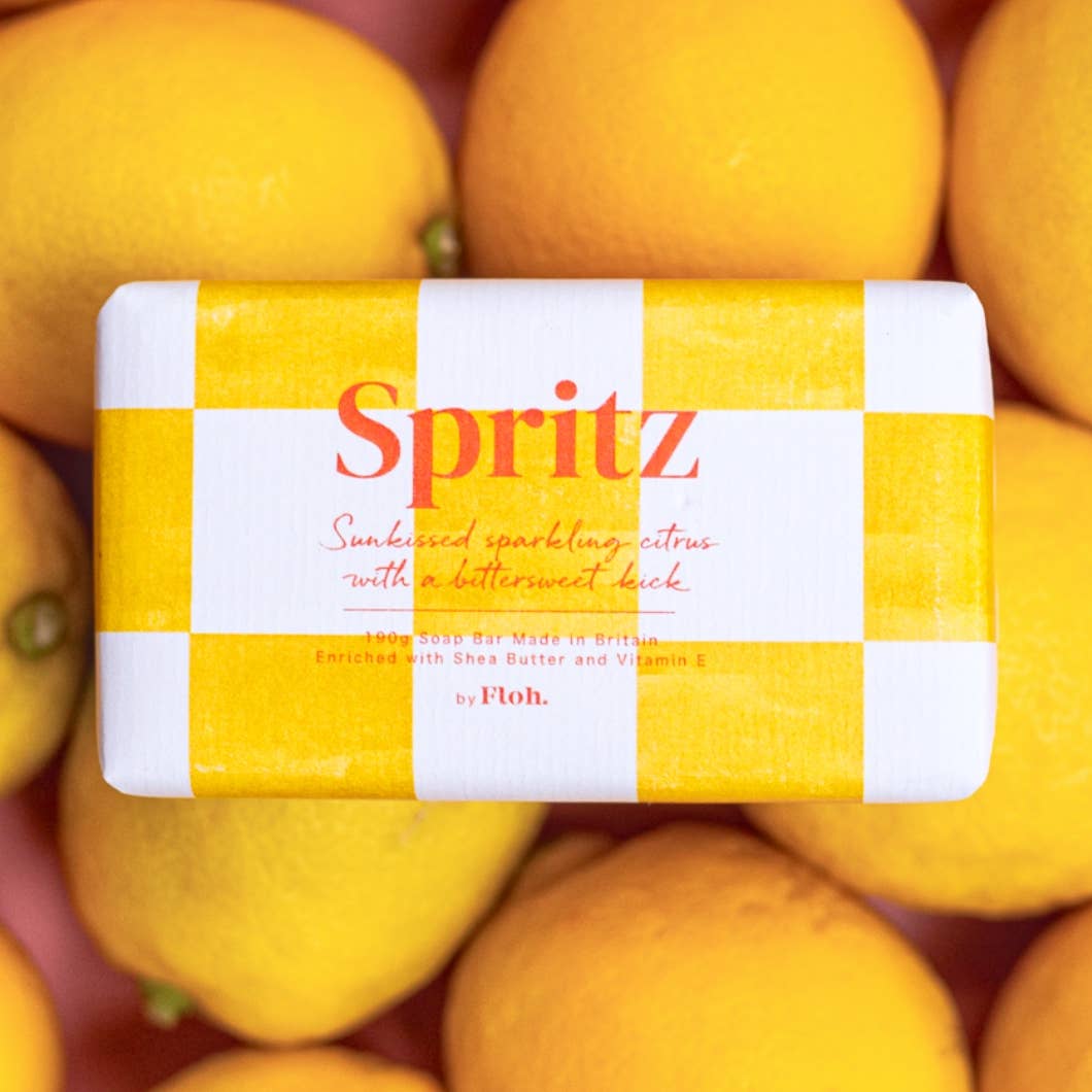 Spritz soap bar with a yellow and white checkered design surrounded by lemons.
