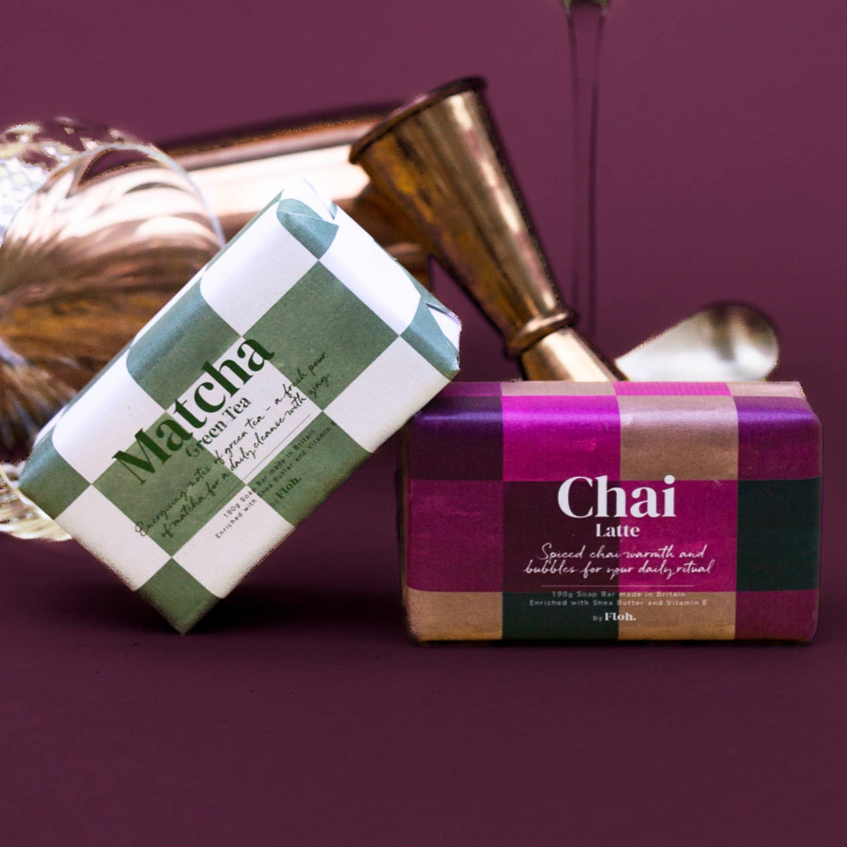 Two soap bars, one labeled 'Matcha' and the other 'Chai Latte', on a purple background.