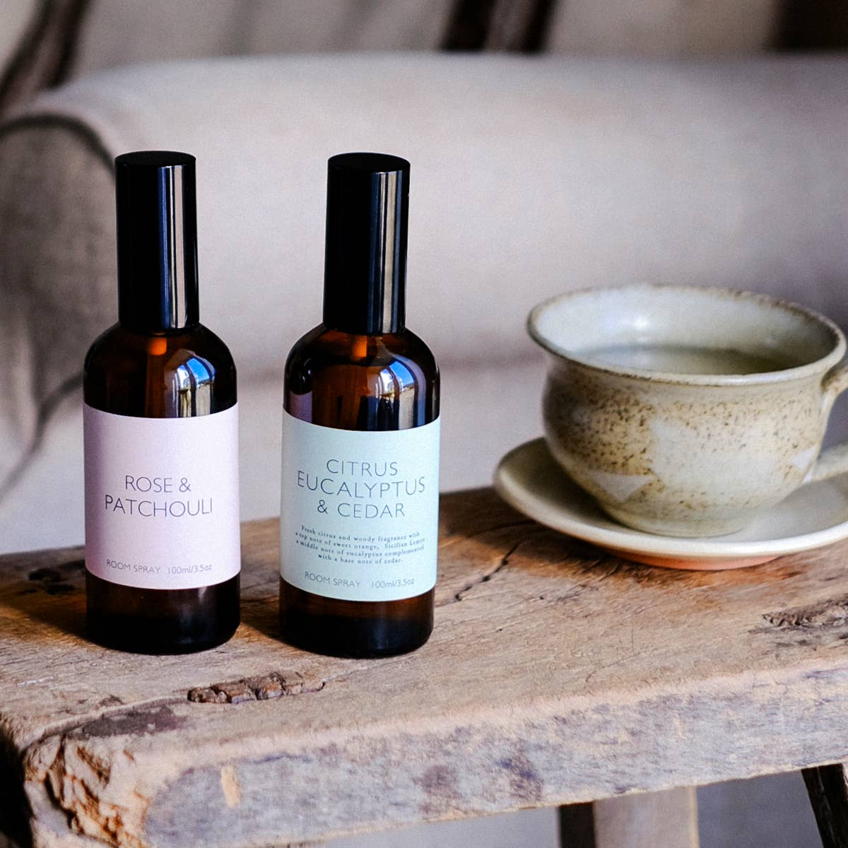 Heaven Scent Room Sparys on a wooden surface with a cup in the background