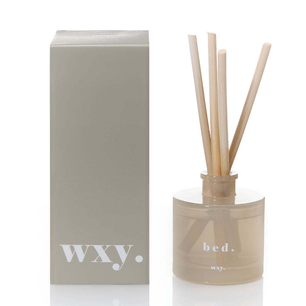 Diffuser with reeds and packaging labeled 'WXY' on a white background