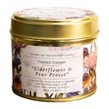 A round metal tin candle with a gold lid and a floral label reading 'Toasted Crumpet design Elderflower & Pear Pressé'.