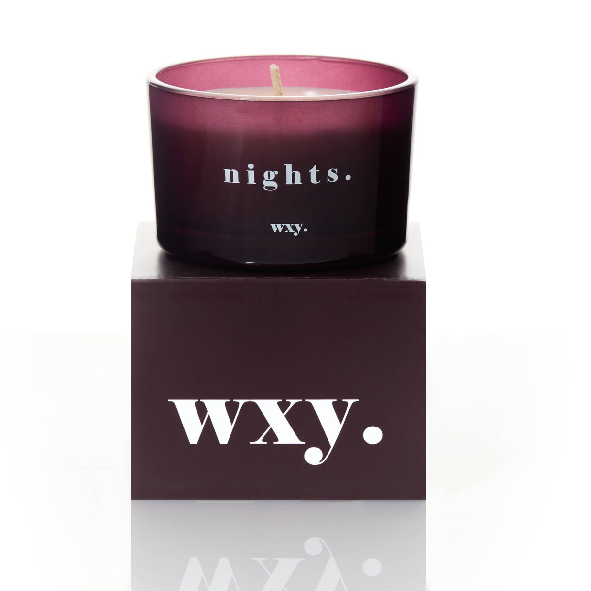 Mauve candle with 'nights.' text on a matching box with 'WXY.' branding.