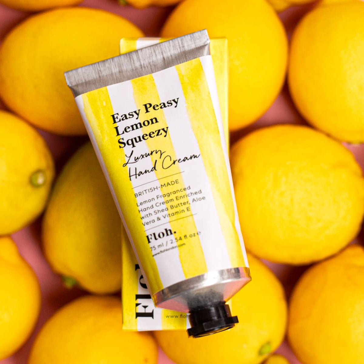 Hand cream tube labeled 'Easy Peasy Lemon Squeezy' surrounded by lemons