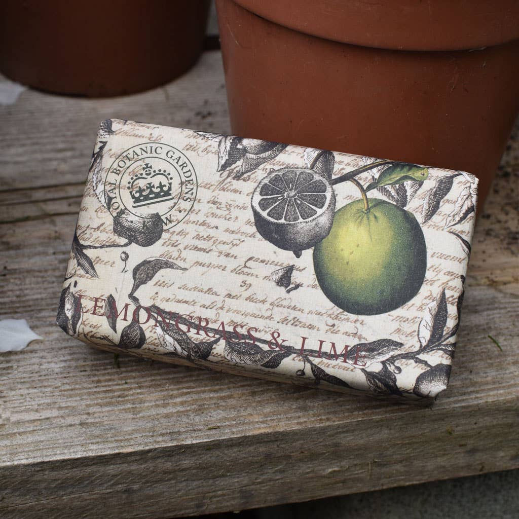 Bar of soap with botanical design on packaging, placed on a wooden surface. - The Fig House