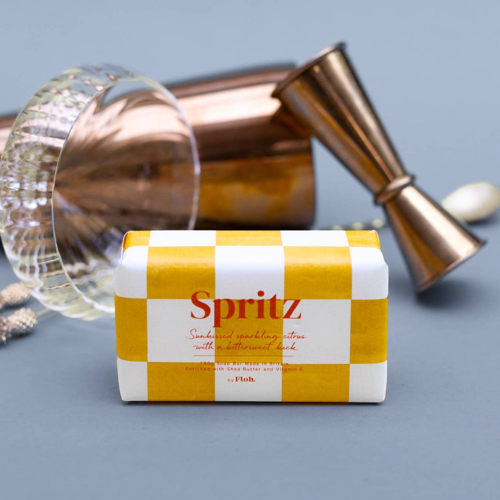 Spritz cocktail mix box with a copper jigger and glass on a gray background