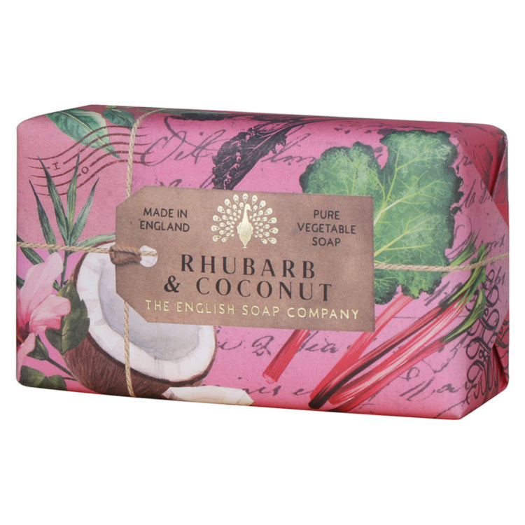 A wrapped bar of soap from The English Soap Company, featuring a pink tropical design with rhubarb leaves, a coconut, and a central brown label that reads 'Rhubarb & Coconut Pure Vegetable Soap Made in England.'.