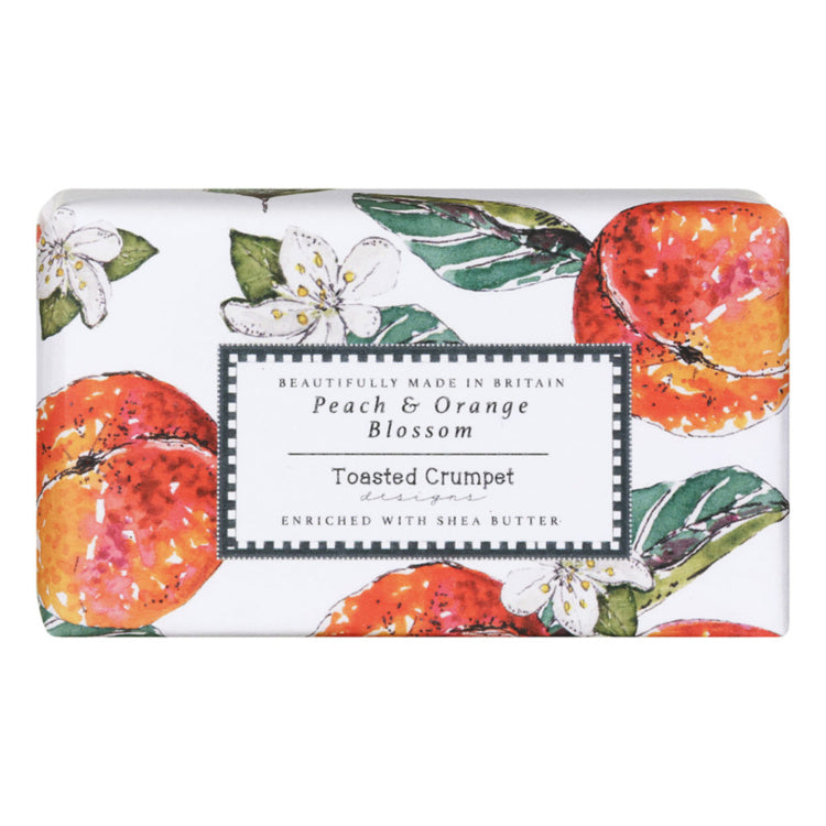 A rectangular bar of soap with a white background and a watercolor-style peach and orange blossom print. A central label reads 'Peach & Orange Blossom' and 'Toasted Crumpet', with 'Beautifully Made in Britain' above.